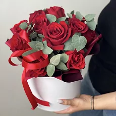 Красные розы в шляпной коробке и зелень