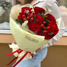 Букет живых цветов из красных роз и гиперикума в дизайнерской упаковке